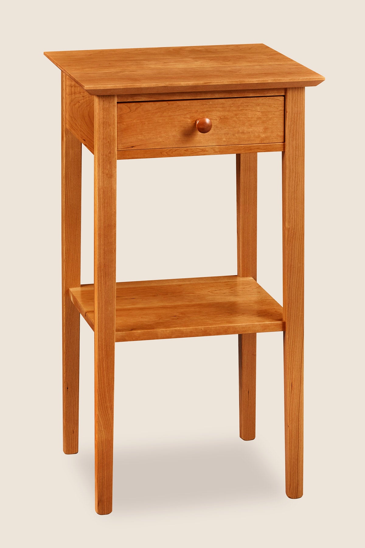 Simple Shaker nightstand with one drawer, shelf, and tapered legs, in cherry wood, from Maine's Chilton Furniture Co.